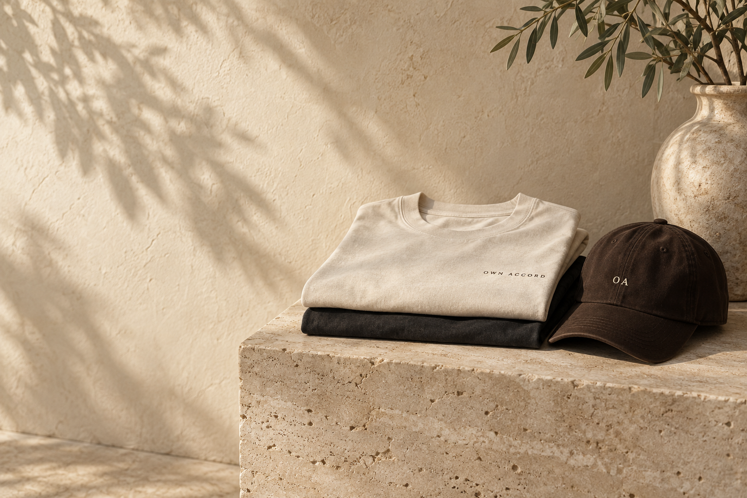OWN ACCORD concept: folded tees and an espresso cap on stone
